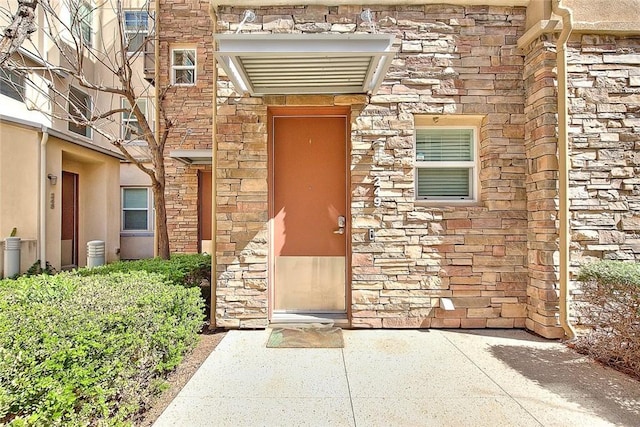 view of exterior entry featuring stone siding