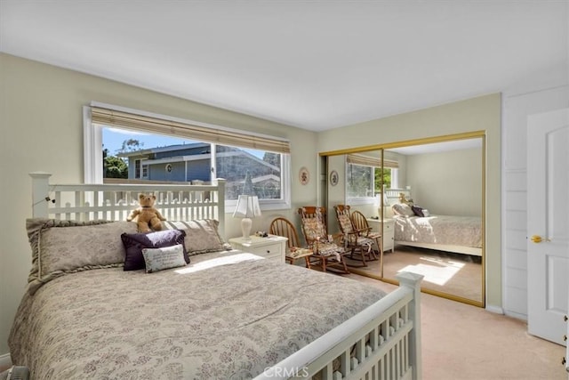 bedroom with baseboards, a closet, and light colored carpet