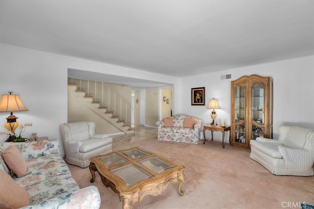 living area with visible vents, stairway, and carpet flooring