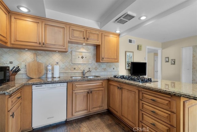 kitchen with dark stone countertops, visible vents, a sink, and black appliances