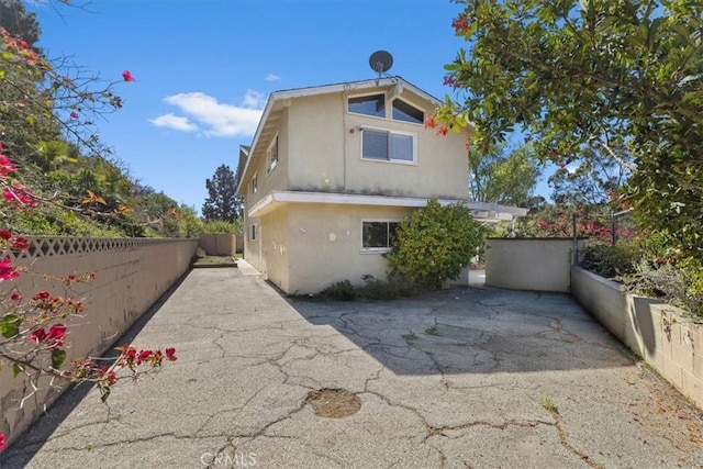 back of property with a fenced backyard, a patio, and stucco siding