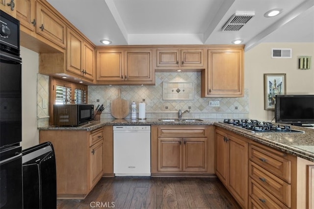 kitchen featuring dark wood-style floors, black appliances, a sink, and visible vents