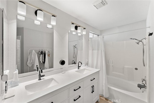 full bathroom with a sink, visible vents, shower / bath combo with shower curtain, and double vanity