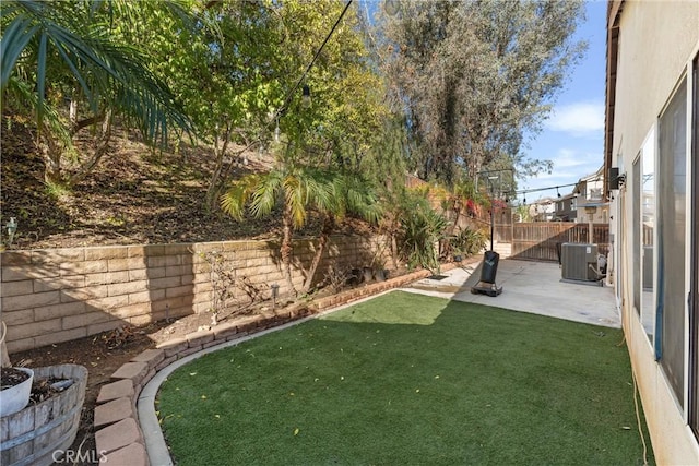 view of yard featuring a patio, a fenced backyard, and central AC