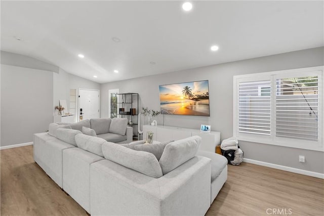 living area with recessed lighting, baseboards, wood finished floors, and vaulted ceiling