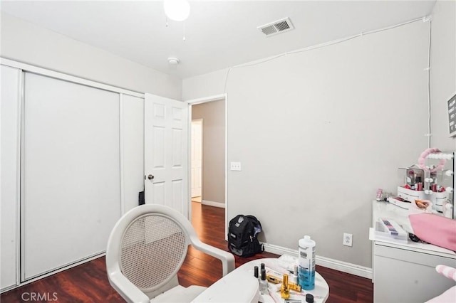 office area featuring baseboards, visible vents, and wood finished floors