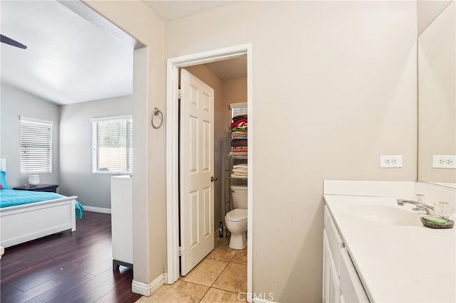 bathroom featuring toilet, vanity, baseboards, and tile patterned floors