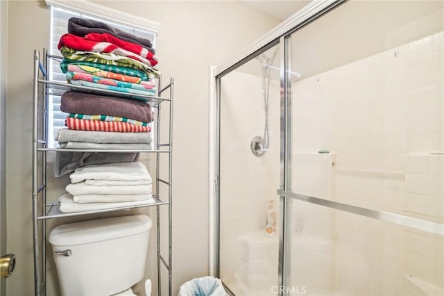 full bathroom featuring a stall shower and toilet