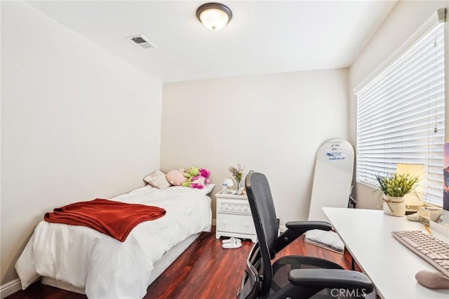 bedroom with visible vents and wood finished floors