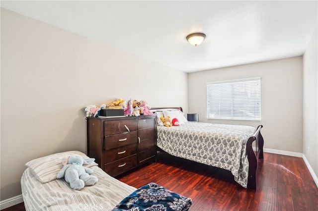 bedroom featuring baseboards and dark wood finished floors