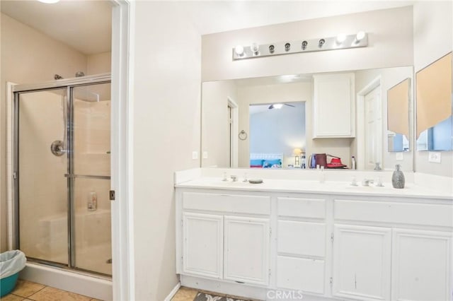 ensuite bathroom featuring double vanity, a stall shower, ensuite bath, and a sink