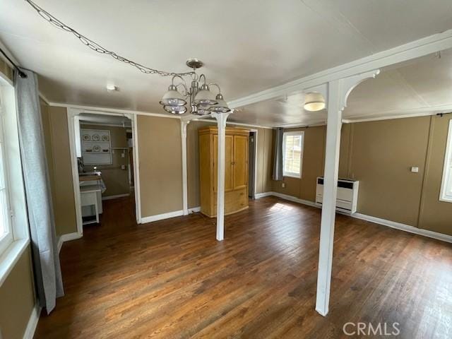 interior space featuring heating unit, baseboards, and wood finished floors