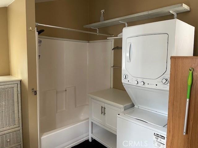 washroom with laundry area and stacked washer / drying machine