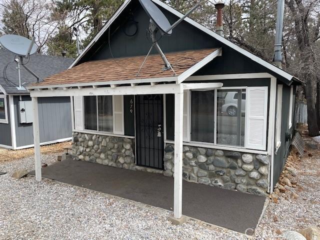 view of front of property with stone siding and a shingled roof