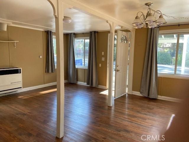 interior space with heating unit, a chandelier, baseboards, and wood finished floors