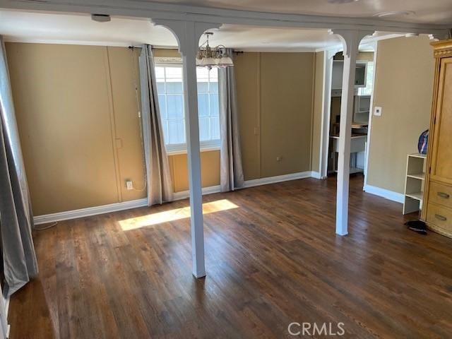 unfurnished dining area with dark wood finished floors and baseboards