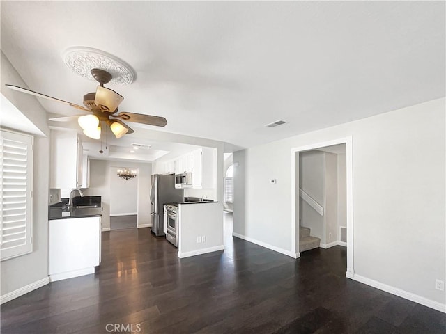 unfurnished living room featuring dark wood-style flooring, a sink, a ceiling fan, baseboards, and stairs