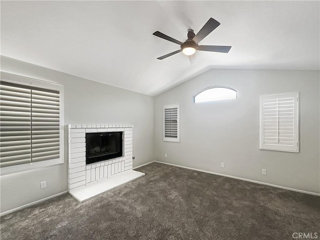 unfurnished living room with baseboards, lofted ceiling, ceiling fan, carpet, and a brick fireplace