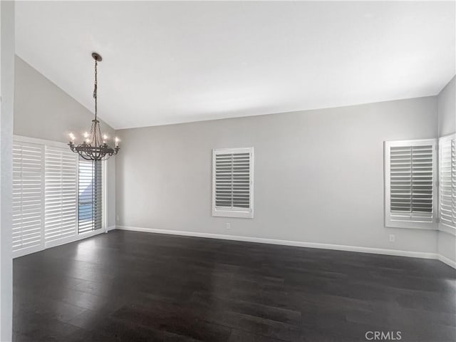 unfurnished room featuring a chandelier, dark wood-style flooring, vaulted ceiling, and baseboards