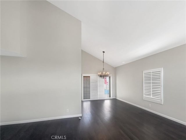 spare room featuring high vaulted ceiling, dark wood-style floors, baseboards, and a notable chandelier