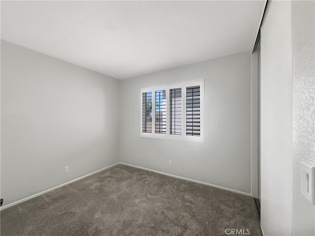 spare room featuring carpet flooring and baseboards