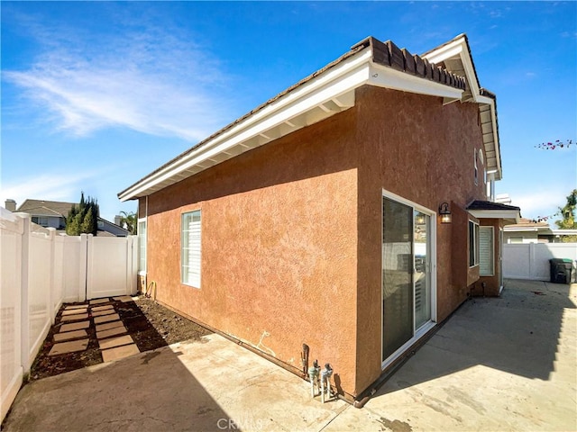 view of property exterior featuring a patio area, a fenced backyard, and stucco siding