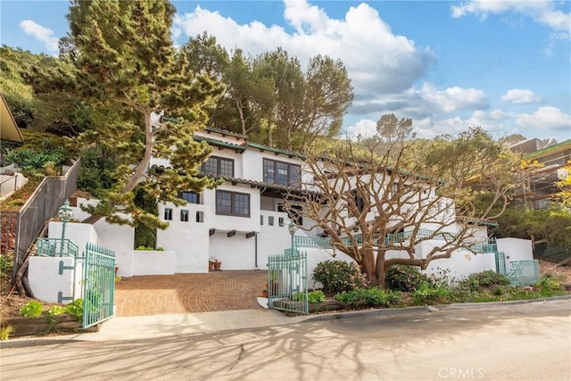 view of front of house featuring a fenced front yard, a gate, and stucco siding