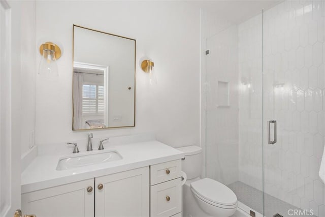 bathroom featuring a shower stall, toilet, and vanity