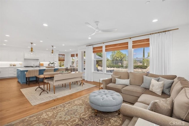 living room with recessed lighting, light wood-style flooring, and a ceiling fan