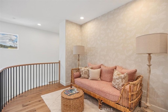 living area featuring wallpapered walls, recessed lighting, wood finished floors, and baseboards