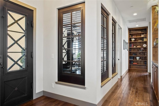 foyer with a healthy amount of sunlight, dark wood-style flooring, recessed lighting, and baseboards