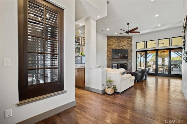 unfurnished living room with recessed lighting, a fireplace, hardwood / wood-style flooring, and baseboards