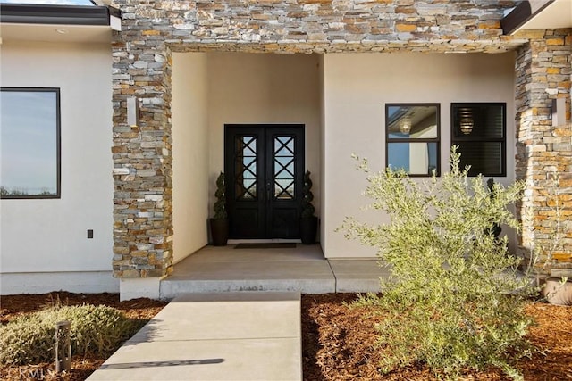 entrance to property with stone siding and stucco siding