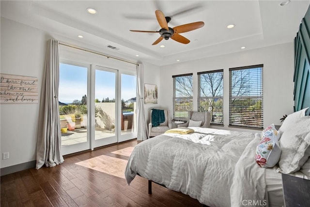 bedroom featuring access to exterior, a tray ceiling, recessed lighting, visible vents, and wood finished floors