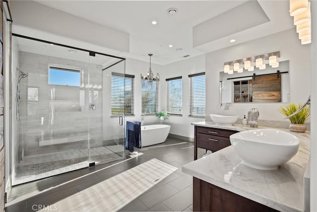 full bath featuring a freestanding bath, double vanity, a stall shower, and recessed lighting