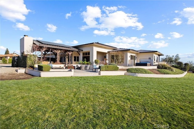 rear view of property featuring a yard, a gazebo, and stucco siding