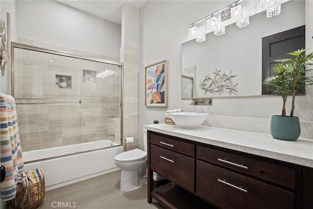 bathroom featuring enclosed tub / shower combo, vanity, and toilet