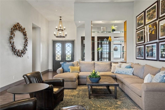 living room with an inviting chandelier, baseboards, wood finished floors, and french doors