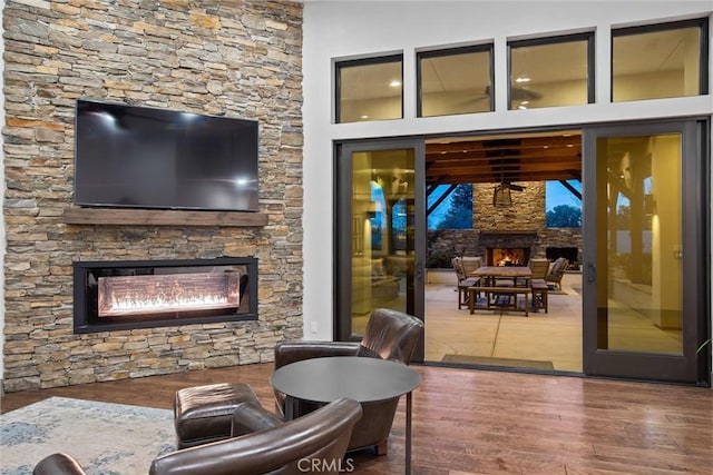 living area with wood finished floors and a glass covered fireplace