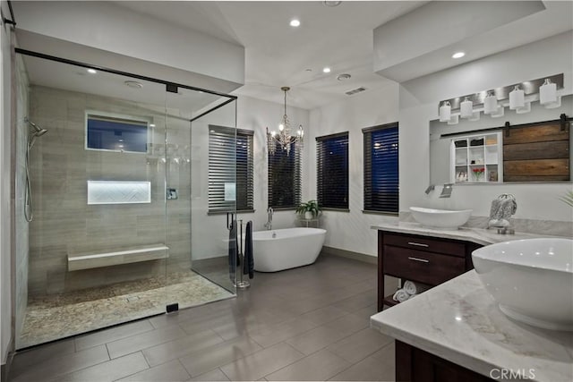 full bathroom featuring a stall shower, a freestanding tub, a sink, and double vanity