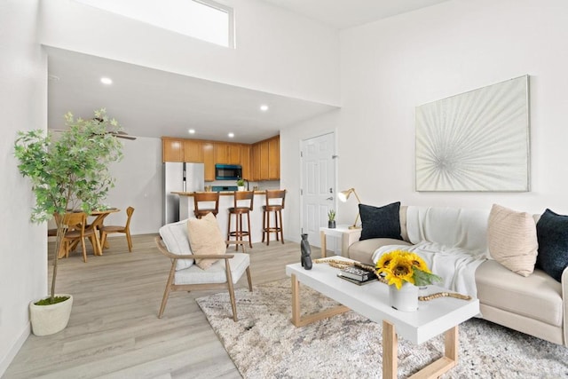 living area with light wood-type flooring and recessed lighting