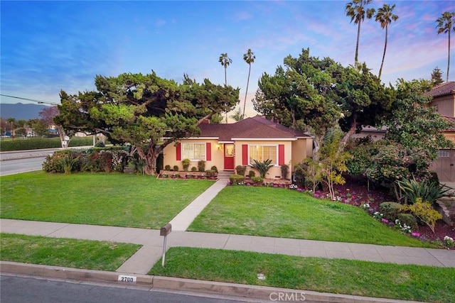 view of front of house with a front yard and stucco siding