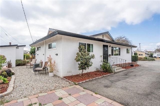 exterior space featuring crawl space, a patio area, and stucco siding