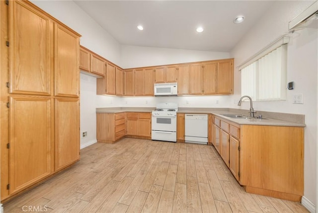 kitchen featuring light countertops, light wood-style floors, a sink, vaulted ceiling, and white appliances