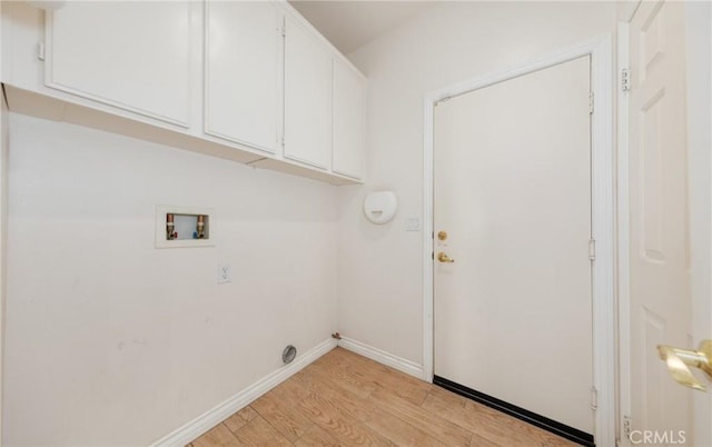 clothes washing area featuring baseboards, washer hookup, cabinet space, and light wood-style floors