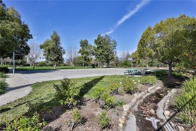 exterior space featuring a yard and community basketball court