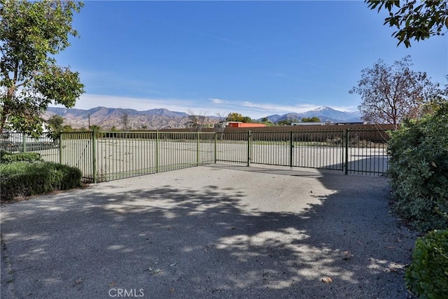 view of gate with a mountain view and fence