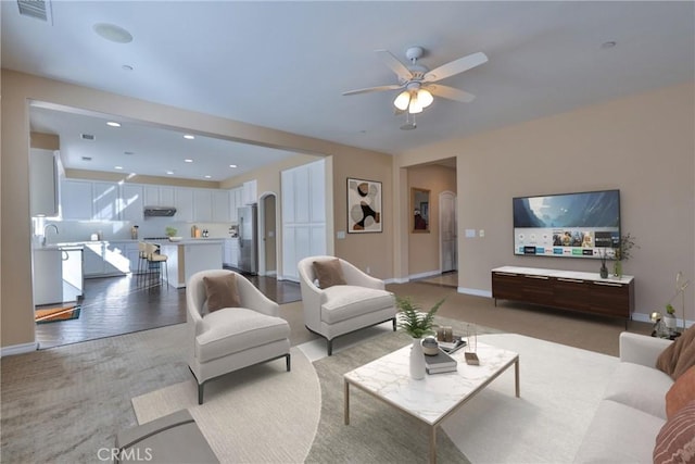 living area featuring recessed lighting, a ceiling fan, visible vents, baseboards, and light wood-type flooring