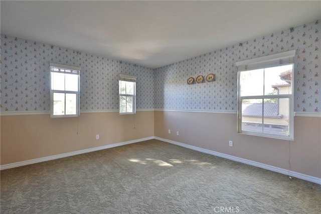 spare room featuring baseboards, carpet floors, and wallpapered walls