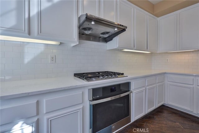 kitchen with under cabinet range hood, white cabinetry, dark wood-style floors, and appliances with stainless steel finishes